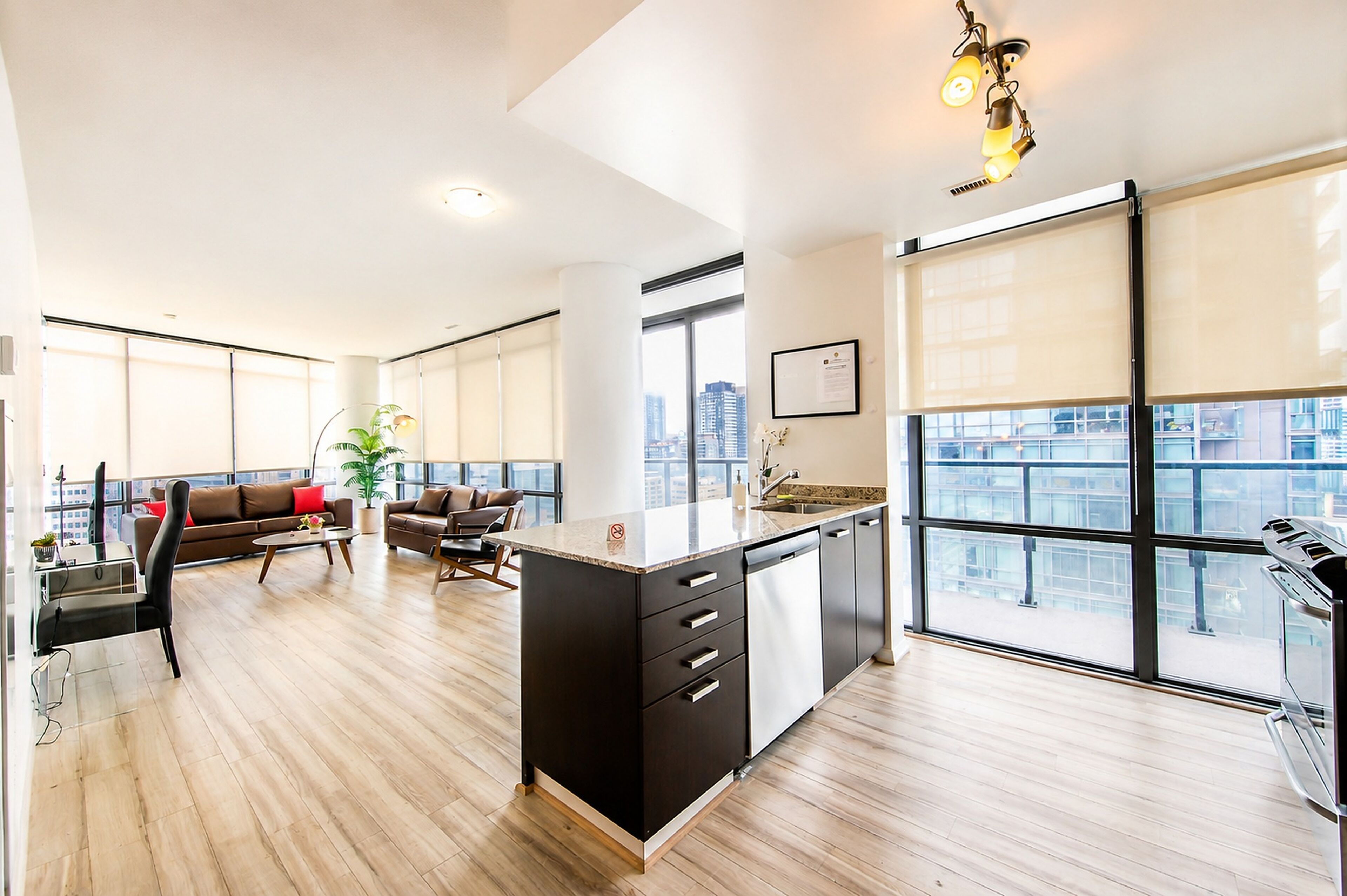Un apartamento moderno con cocina, sala de estar y ventanas amplias que ofrecen vistas a la ciudad.