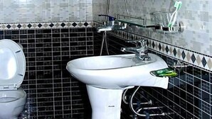 Un baño con inodoro, lavamanos y ducha.
