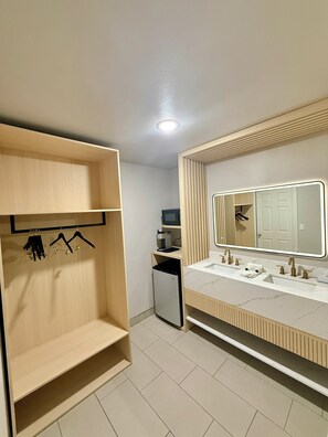 Un baño moderno con tocador de madera, un espejo grande y un calentador integrado.