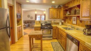 A kitchen with wooden cabinets, a stainless steel refrigerator, a gas stove, and a dishwasher. - Breezy Pines Cabin | Backyard Picnic | BBQ (South Lake Tahoe)