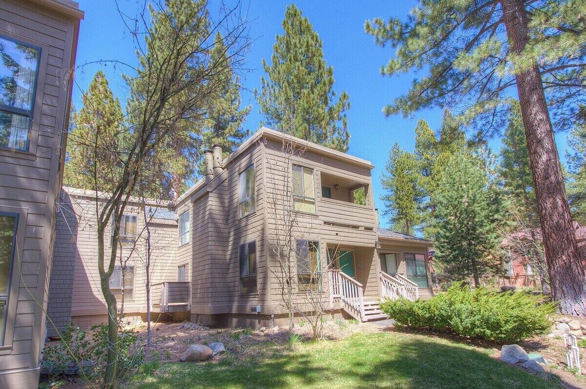 A two-story house with a front porch and a staircase leading to the second floor.
