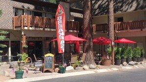 Een restaurant met terras, rode parasols en een bord dat aangeeft dat het vandaag gesloten is.