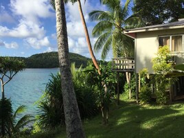 A tropical resort with a view of a calm lake and a mountain in the background.