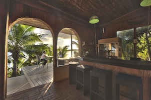 An indoor bar area with a wooden ceiling, a bar counter, and seating.