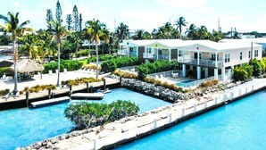 Ett semesterhotell med en stor pool, flera gästvillor och en frodig, tropisk trädgård.
