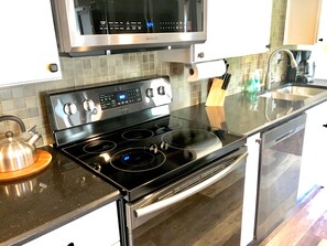 Enjoy cooking in this well-equipped kitchen with a range, microwave, double oven, and sink.
