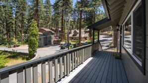 A wooden deck with a railing overlooking a residential street with houses and a clear sky. - Walk to Beach | Pet-Friendly | Deck | BBQ (Zephyr Cove)