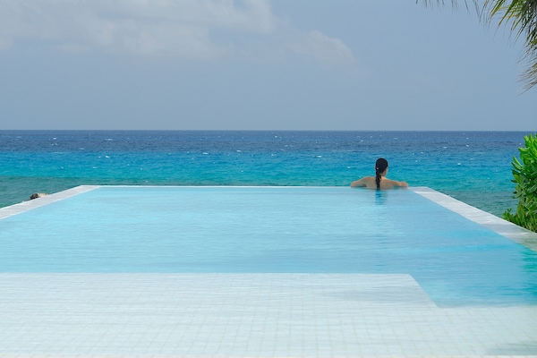 Una piscina al aire libre, sillones reclinables de piscina