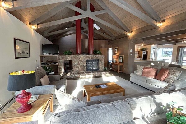 Cozy living area with a stone fireplace, comfortable seating, and a modern TV.