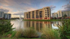 A multi-story residential building with a central courtyard and a fountain. - Sunny 3BR/ 2bath w/ Hot Tub~Beach Access + Pool + Tennis + BBQ + Gated Community (New Smyrna Beach)