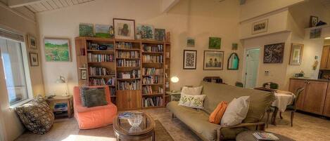 A cozy living room with a sofa, a coffee table, and a bookshelf filled with books.