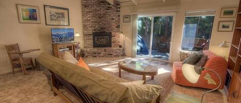A cozy living room with a fireplace, a sofa, a coffee table, and a television.
