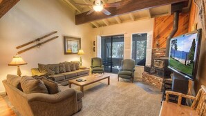 Una sala de estar acogedora con un sofá, sillas, una mesa de centro, chimenea y televisor.