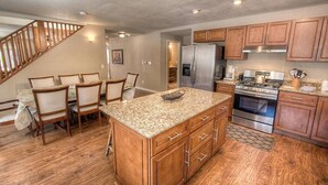 A spacious kitchen with wooden cabinets, a granite countertop, and stainless steel appliances.
