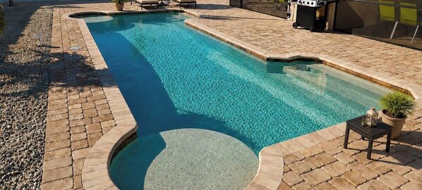 A swimming pool with lounge chairs, a grill, and a covered patio area. - FIFA World Cup 2026- Special Offer! (Cape Coral)