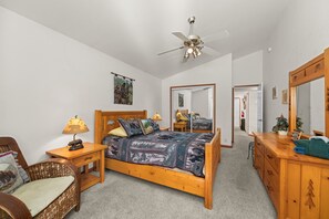 A bedroom with a wooden bed, a nightstand, a chair, a dresser, a ceiling fan, and a mirror. - Hot Tub | Deck | BBQ | Backyard (South Lake Tahoe)