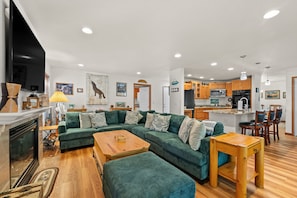 A modern living room with a sectional sofa, a wooden coffee table, and a fireplace. - Hot Tub | Deck | BBQ | Backyard (South Lake Tahoe)