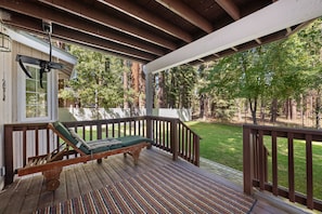 A wooden deck with a single lounge chair and a patterned rug. - Hot Tub | Deck | BBQ | Backyard (South Lake Tahoe)