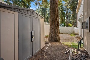 A utility shed with a padlock, a tree, and a gravel path. - Hot Tub | Deck | BBQ | Backyard (South Lake Tahoe)