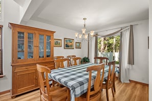 A dining room with a wooden cabinet, a chandelier, and a table with chairs. - Hot Tub | Deck | BBQ | Backyard (South Lake Tahoe)