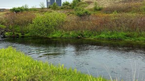 Un río con un edificio en una colina al fondo.