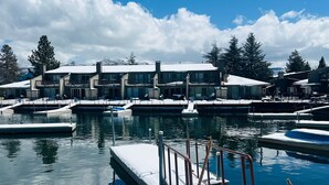 Marina con muelles privados, un muelle cubierto de nieve y un cartel que indica 'Mantenga la puerta cerrada' y 'Peligro, hielo dentro'.