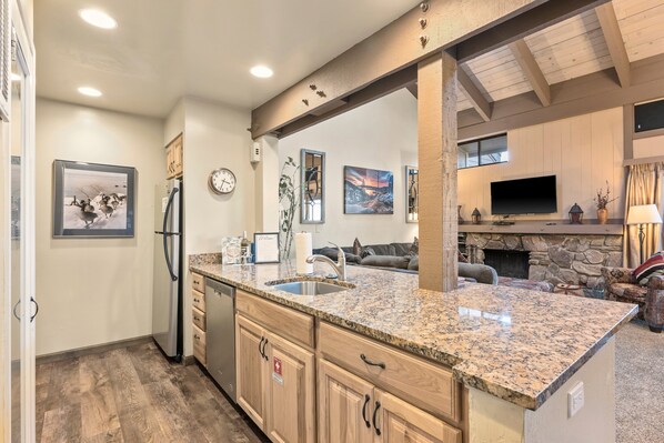A modern kitchen with granite countertops, wooden cabinets, and a built-in stove. - Steps to Beach | Views | Shared Pool & Hot Tub (South Lake Tahoe)