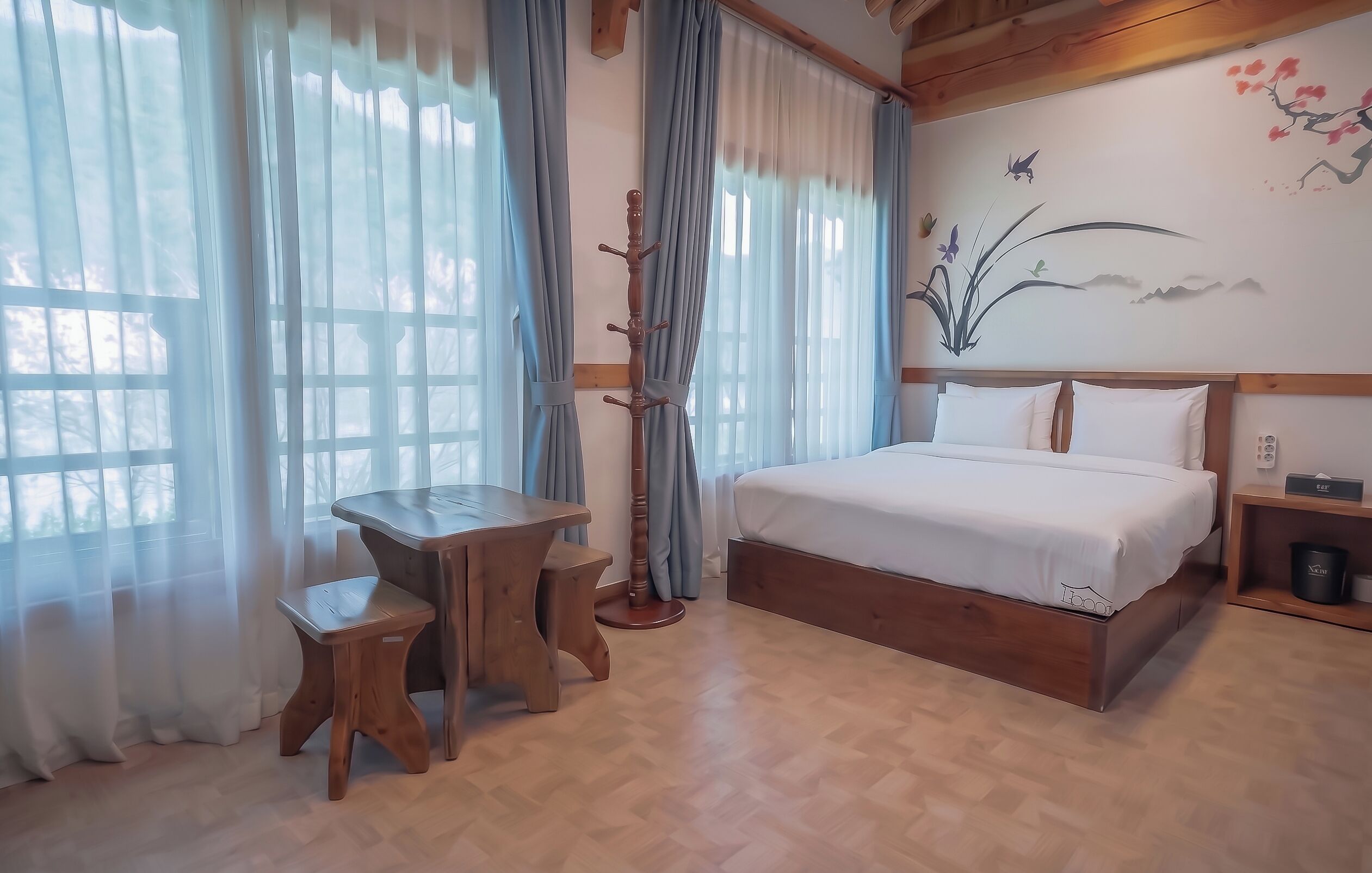 Un dormitorio con una cama de madera, una mesita de madera y una silla.