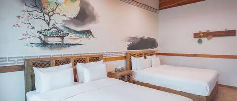 A hotel room with two beds, a wall mural, a wooden headboard, and a ceiling fan.