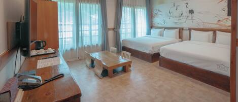 A room with a wooden ceiling, a bed, a desk with a telephone, and a painting on the wall.