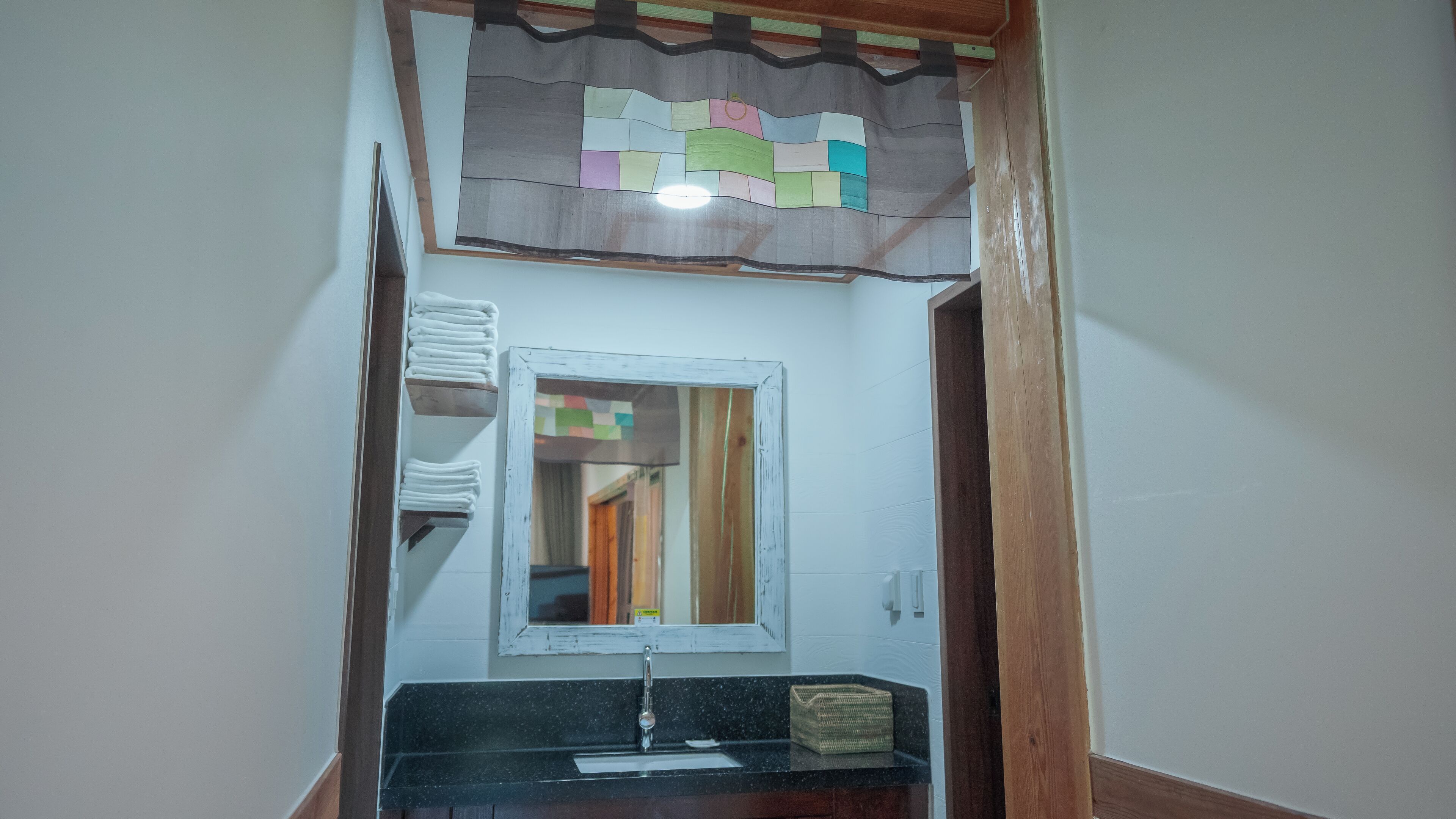 A bathroom with a mirror, sink, and towel rack.