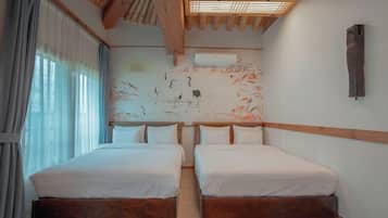 A room with two beds, wooden headboard, a wall with a nature-themed mural, and an air conditioning unit.