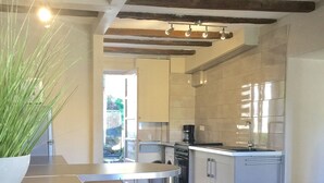 Une cuisine moderne avec un coin bar, des appareils en acier inoxydable et une vue sur le jardin arrière.