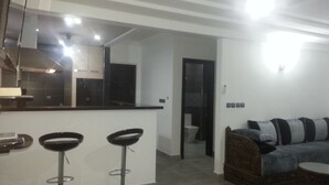 Een moderne keuken met een bar, een bank en een eettafel.