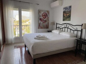 Une chambre d’hôtel avec un lit, une table de chevet, une lampe, un tableau et une vue par la fenêtre.
