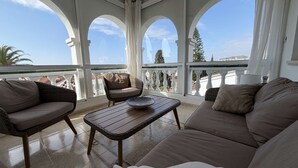 A balcony with wicker furniture, a view of the city, and a clear sky. - Villa Sandra Top Floor Escape by Casasol (Nerja)