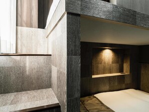 A modern bedroom with a bunk bed, a bedside table, and a wall-mounted light fixture. - Hotel Areaone Kitaibaraki (Kitaibaraki)