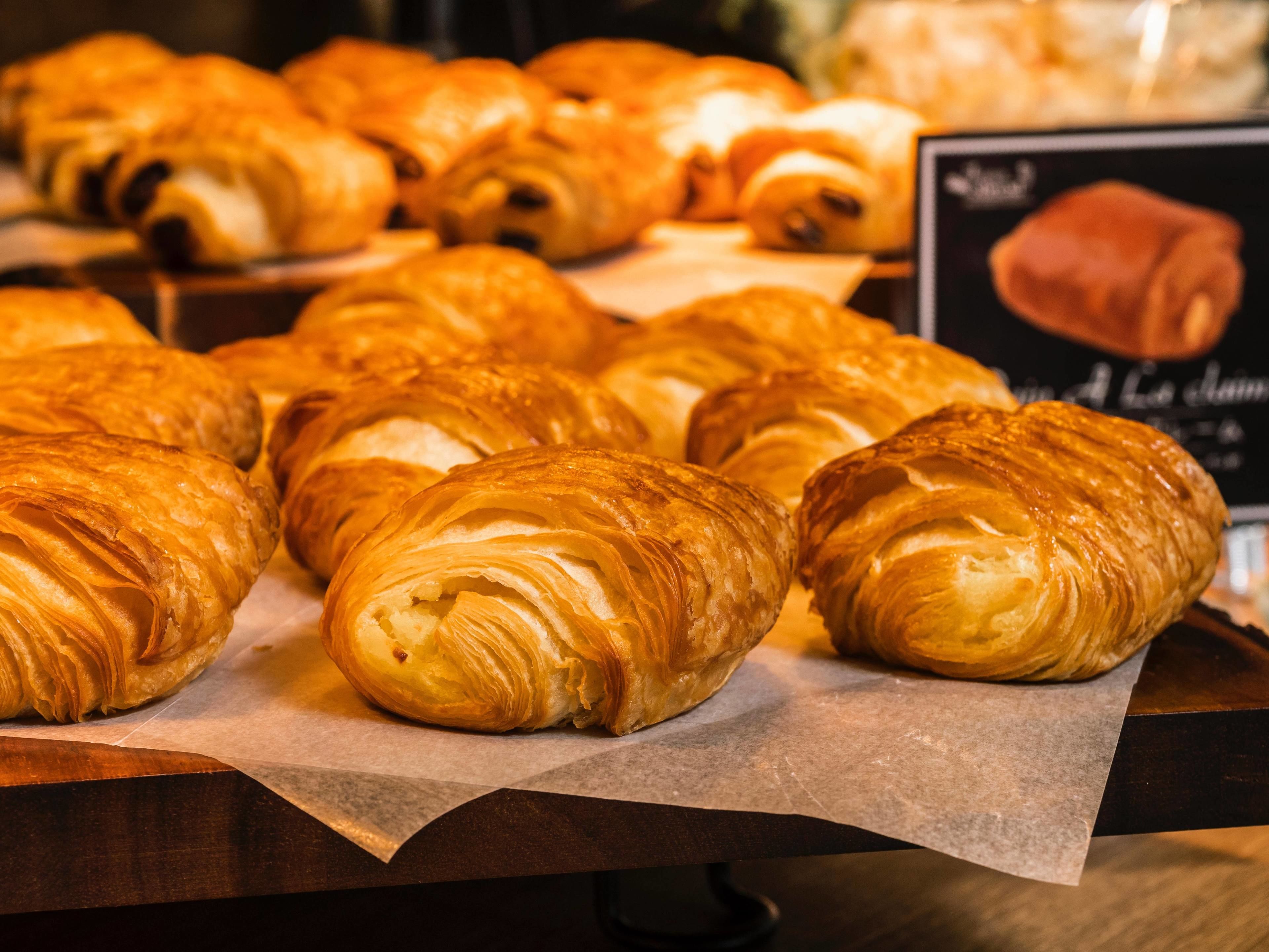 Exibição de croissants sobre um balcão de madeira.