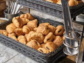 Variedad de pasteles en cestas de mimbre, con un soporte de metal para cucharas a la vista.
