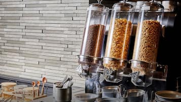 Montaje de bufé con varios recipientes de comida y utensilios.