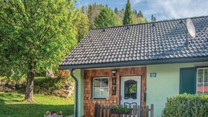 A small, single-story building with a tiled roof, a wooden door, and a small porch.