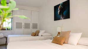 A hotel room with two beds, a large window, a painting, and a wardrobe. - Múcura Hotel & Spa (Cartagena)