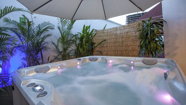 A hot tub with a control panel, surrounded by plants and a bamboo fence. - Múcura Hotel & Spa (Cartagena)