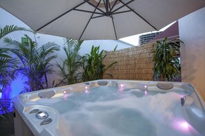 A hot tub with a control panel, surrounded by plants and a bamboo fence. - Múcura Hotel & Spa (Cartagena)