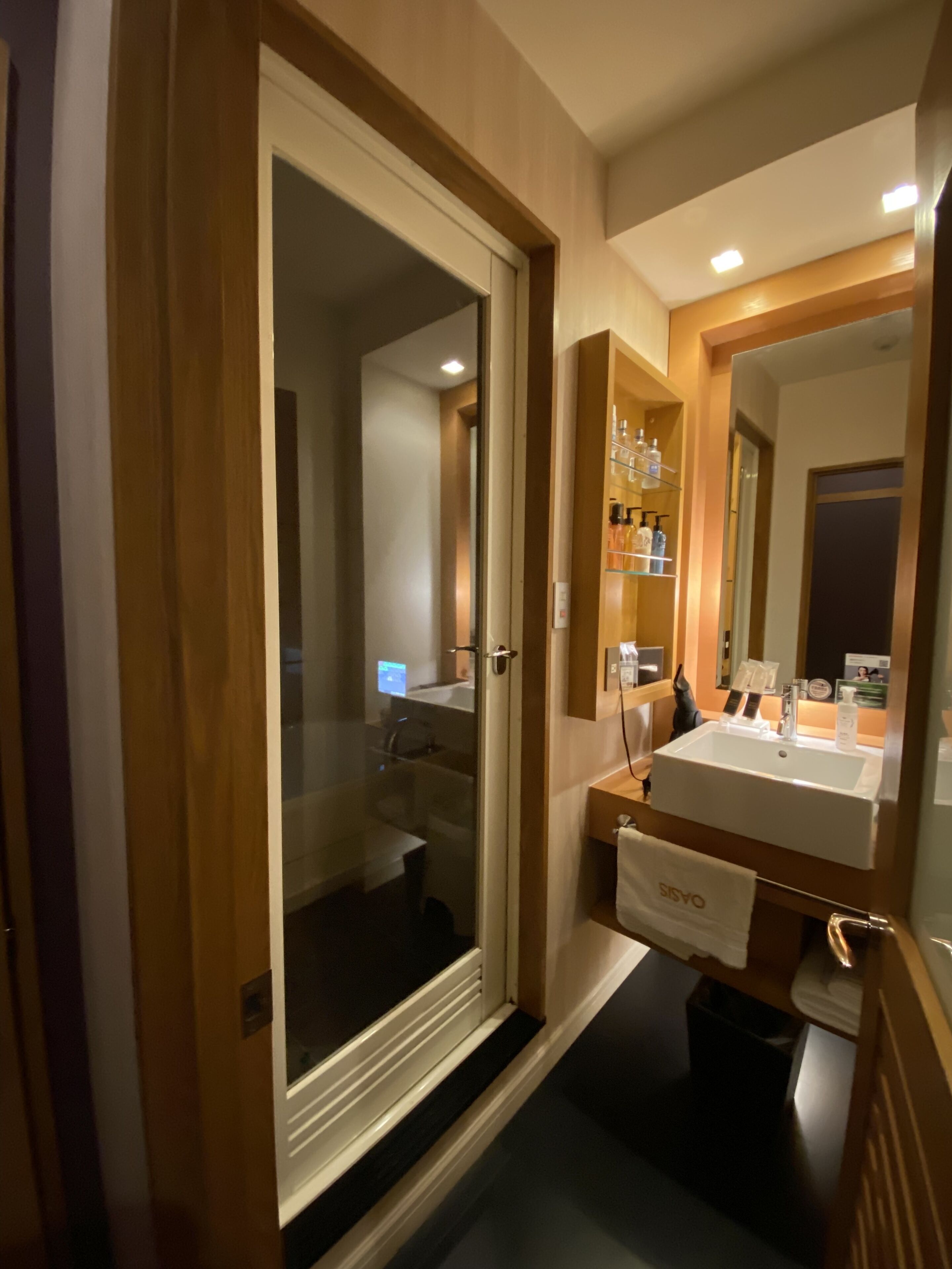Une salle de bain moderne avec une douche à parois de verre, un meuble-lavabo avec un évier et un miroir, et un porte-serviettes.