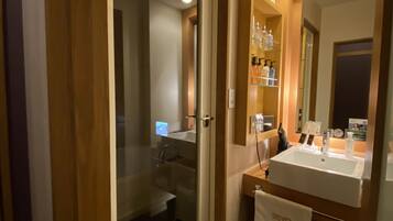 Une salle de bain moderne avec une douche à parois de verre, un meuble-lavabo avec un évier et un miroir, et un porte-serviettes.