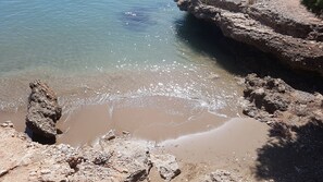 A rocky beach with clear water and a rocky shoreline.