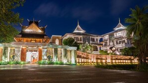A traditional building with a central entrance, surrounded by a well-maintained garden and a paved pathway leading to it. - Shinnabhura Historic Boutique hotel (Phitsanulok)