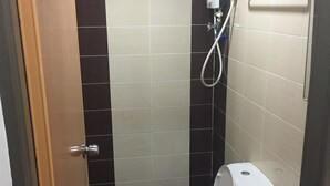 A small, compact bathroom with a toilet, bidet, and shower.