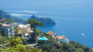 Una propiedad costera con piscina, vistas al mar y una pequeña isla.